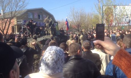 Crowds look on as pro-Russian separatists drive round the city on armoured vehicles