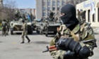Armed men wearing military fatigues gather by APCs as they stand guard in Slavyansk, Ukraine.