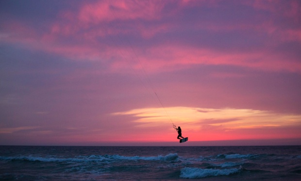 A man surfs with his kite in the Mediterranean sea in Ashkelon, Israel.