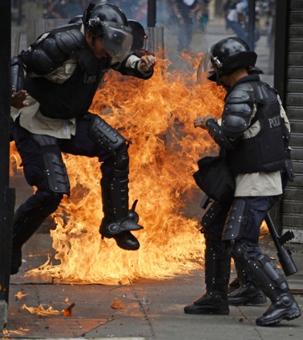 A member of the National Police runs away from fire after anti-government protesters threw a Molotov cocktail at them during clashes in Caracas. Anti-government protests have beset Venezuela since February, leaving at least 41 people dead and more than 600 injured.