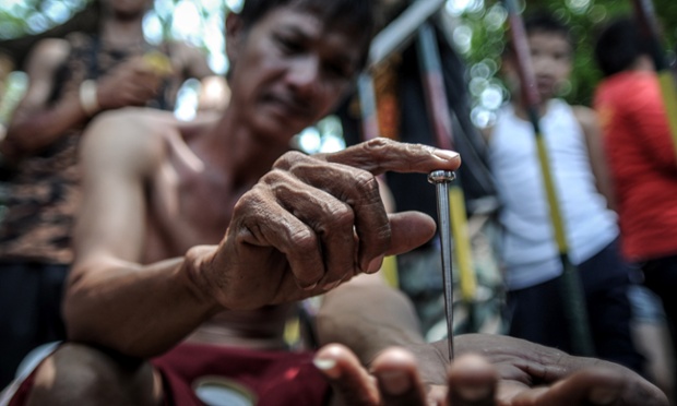 Danillo Castro shows a five-inch nail that will be used in his re-enactment of the crucifixion on Good Friday in San Fernando, Philippines