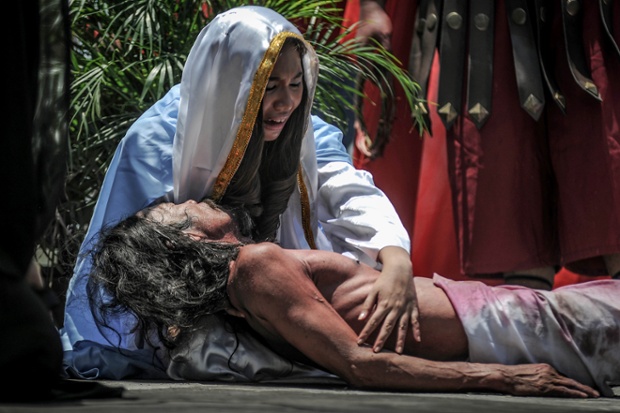 Penitents take part in a re-enactment of the  crucifixion in San Fernando, Philippines.