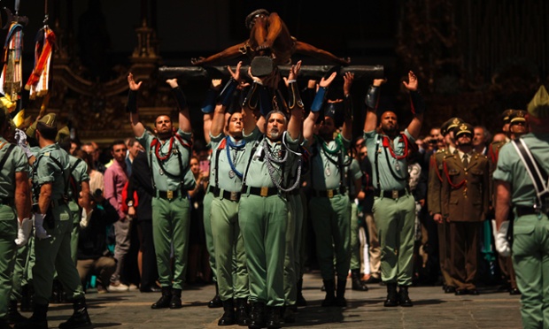 Spanish legionnaires carry a statue of the Christ  during a ceremony before they take part in the Mena brotherhood procession in Malaga, Spain.