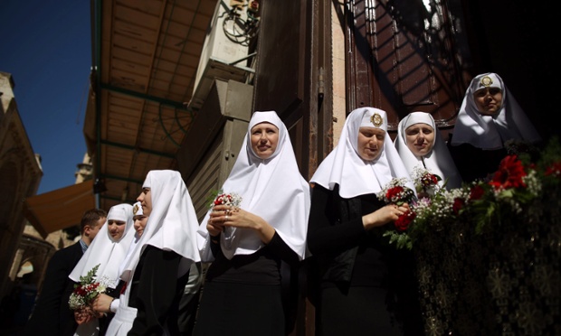 Russian Orthodox nuns hold flowers during a Good Friday procession near the church of the Holy Sepulchre, in the Old City of Jerusalem.
