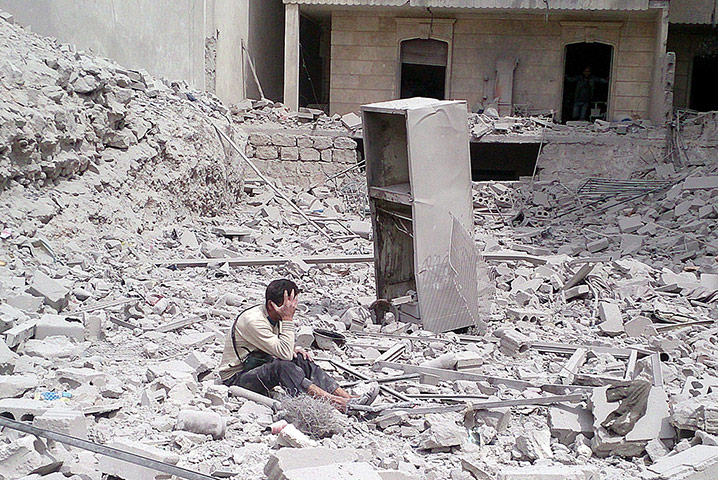 20 Photos: a Syrian man surveys the damage caused by barrel bombs in Aleppo