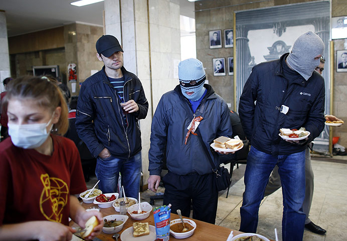 20 Photos: Masked pro-Russia protesters wait in a queue for food in Donetsk