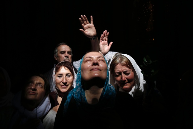 Jerusalem: Worshippers react to a beam of sunlight filtering from the ceiling as they take part in the holy fire ceremony at the Church of the Holy Sepulchre