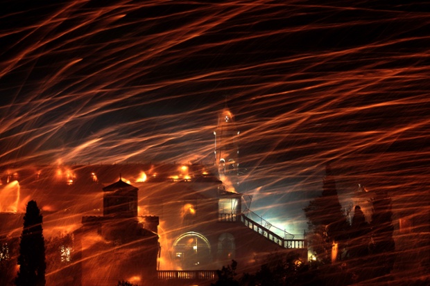 Chios, Greece: Rockets fly over the bell tower of Panagia Erithiani church, during Greek Orthodox Easter celebrations on the Aegean island.
