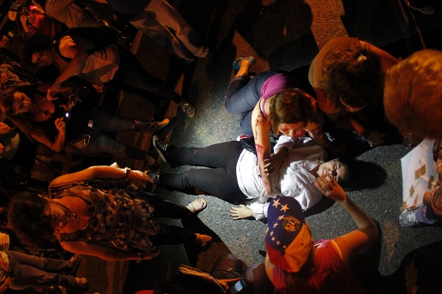 Caracas, Venezuela: A protester lies on the ground  after being hit by a vehicle during an anti-government rally