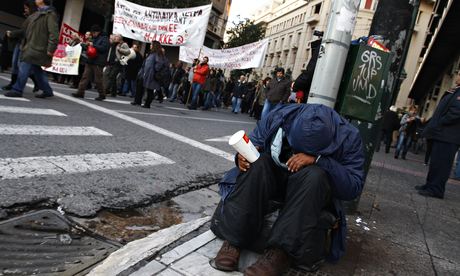 A man begs on a street in Athens during an anti-austerity demonstration