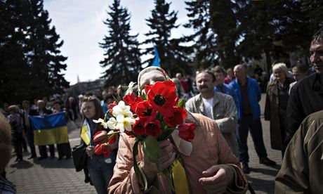 A Ukrainian woman holds a bouquet during a pro Ukrainian rally in Khartsyzk, Ukraine