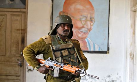An Indian soldier stands guard at a polling station