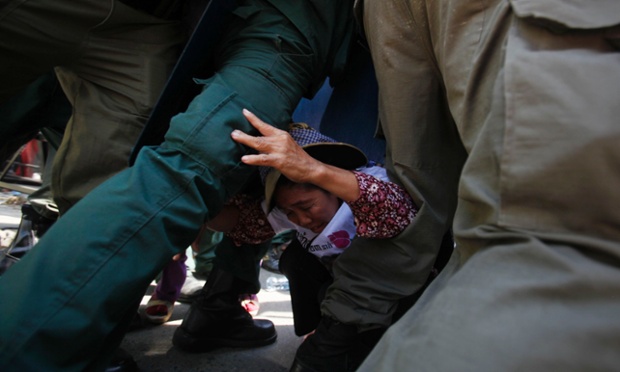 Police officers prevent a protester from going toward the Phnom Penh Municipal Court, Cambodia.