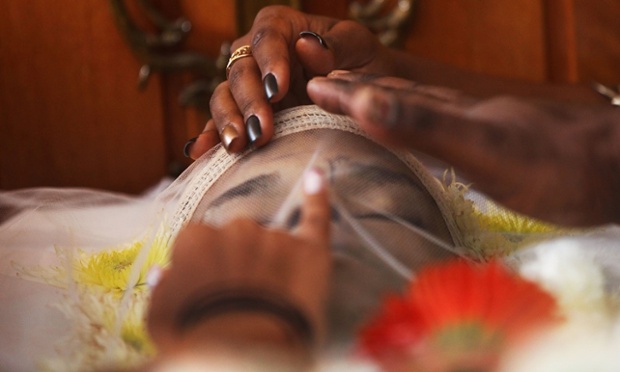 Mourners stand over the body of dancer Douglas Rafael da Silva at his funeral, in Rio de Janeiro, Brazil.