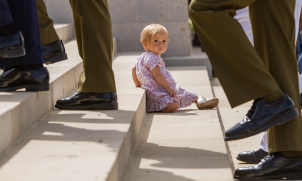 A young girl sits on the floor during an official memorial ceremony held at the First World War British cemetery in Mount Scopus in Jerusalem.