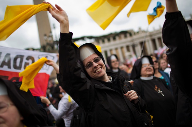 Nuns wave as Pope Francis is driven through the crowd.