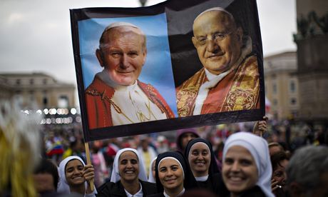 Nuns among the 800,000 pilgrims hold up portraits of Pope John Paul II, left, and Pope John XXIII
