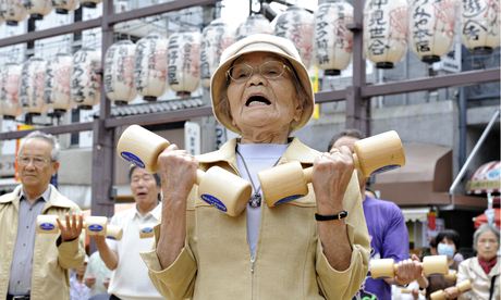 Elderly people work out with wooden dumb