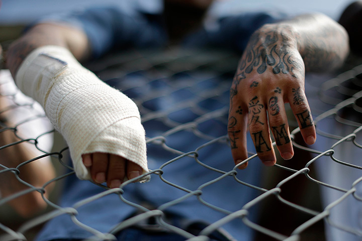 FTA: Angola Prison Rodeo: Inmates lean on a fence as they watch visitors arrive