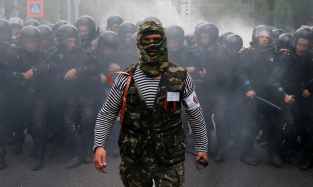 A pro-Russian activist walks in front of Ukrainian riot police during a pro-Ukrainian rally in the eastern city of Donetsk April 28, 2014.