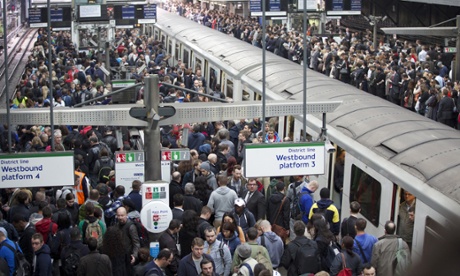 Commuters try to get on a train on the District Line of the London Underground during the 48-hour tube strike at London's Earl's Court tube station.