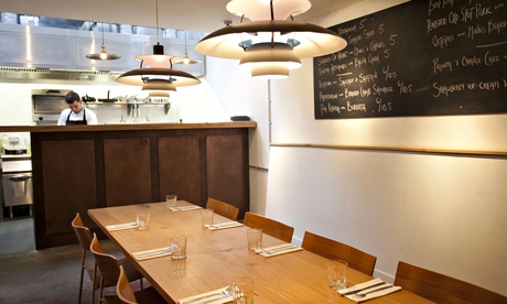 Long table at Artusi with hanging lamps and chalkboard