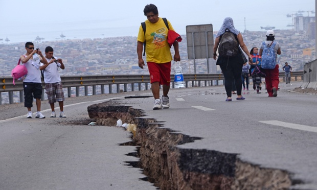 People walk along a cracked road in Iquique after a powerful 8.2-magnitude earthquake hit off Chile's Pacific coast.