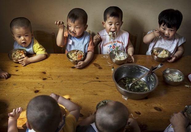 Young orphaned Chinese children eat a meal at a foster care centre in Beijing, China.