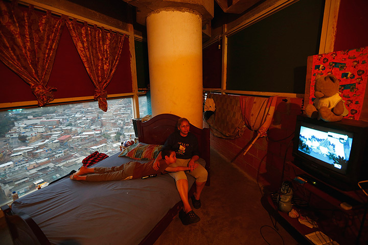 Tower of David: Adriana Gutierrez and her son Carlos Adrian watch TV as they sit on their b
