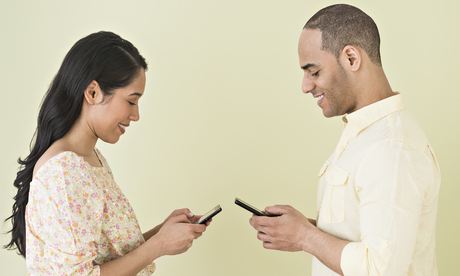 A young couple with identical mobile phones