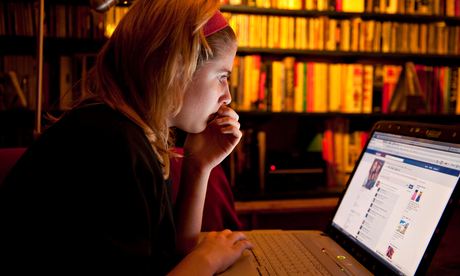 Girl looks at Facebook on her laptop