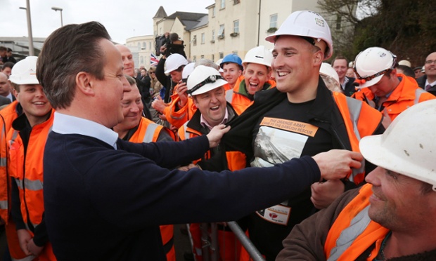 David Cameron admires railway worker Ross McCulloch's t-shirt which shows pictures of the storm damaged railway line at Dawlish Railway Station. The railway line has re-opened after track near the town was damaged in the winter storms.