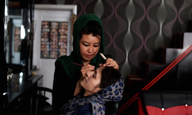 Twenty-five year old Afghan beautician Salma Haidari takes care of a client as she works at a salon in Kabul. Behind the opaque windows of the Black Diamond beauty parlour in western Kabul, Saturday's election has been a prime subject of conversation among clients dropping in for manicures, eyebrow grooming and massages.