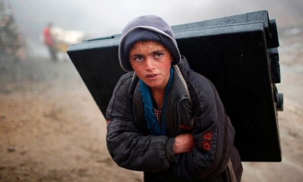 An Afghan boy carries election material on his back to polling stations which are not accessible by road in Shutul, Panjshir province
