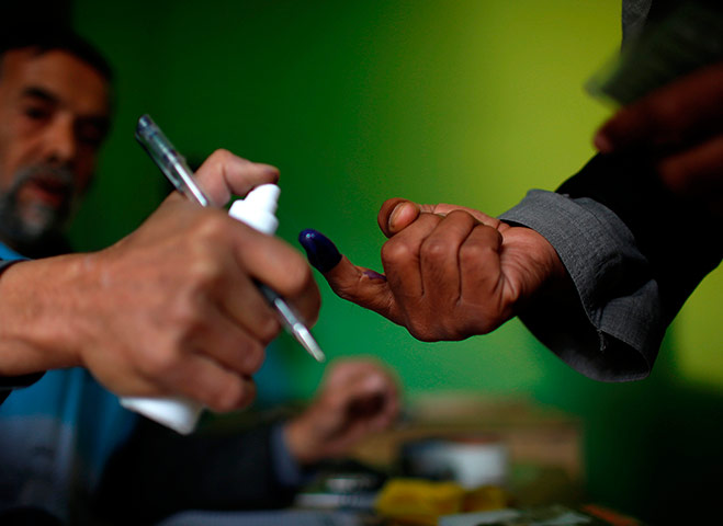 Afghan: An election officer sprays liquid on the finger of a voter