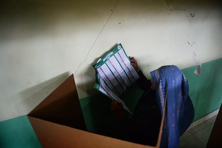 A voter looks at the long list of candidates for provincial councils as she gets ready to cast her ballot at a local polling station in Kabul.