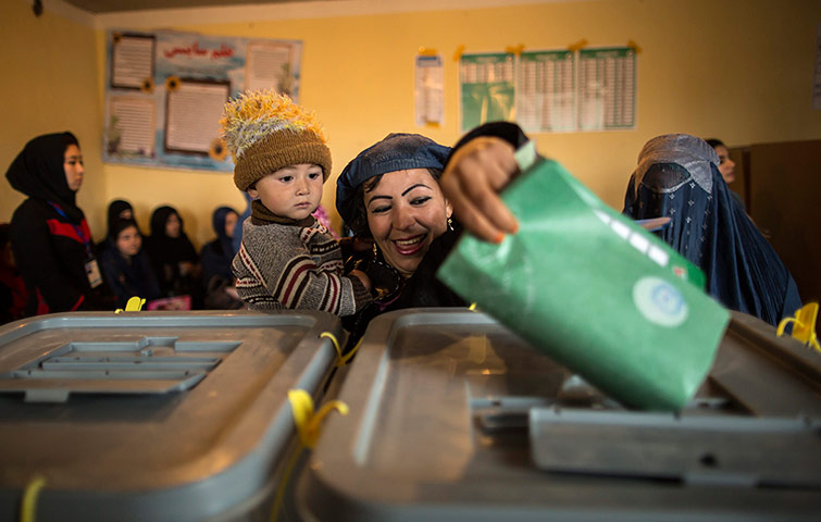 Afghan: A woman casts her ballot at a polling station in Mazar-i- sharif