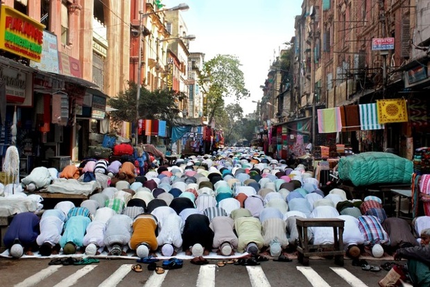 Muslims take part in noon prayer on the main market street outside a local Musjid in Panditya Basti.