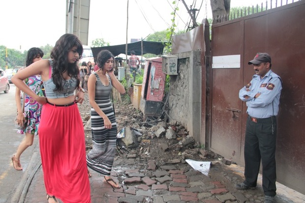 Young women walking past security to a gig at a popular music venue.