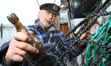 German fisherman Konrad Fischer holds the  message in a bottle from 1913 that was found recently.