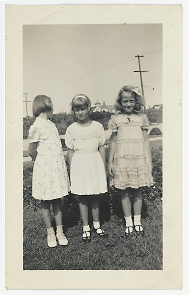 Girls Standing on Lawns: Three girls on a lawn