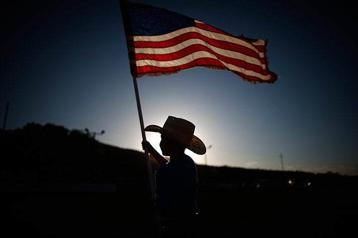 From the agencies: Esteban Edwards holds a US flag at the rodeo in Truth or Consequences