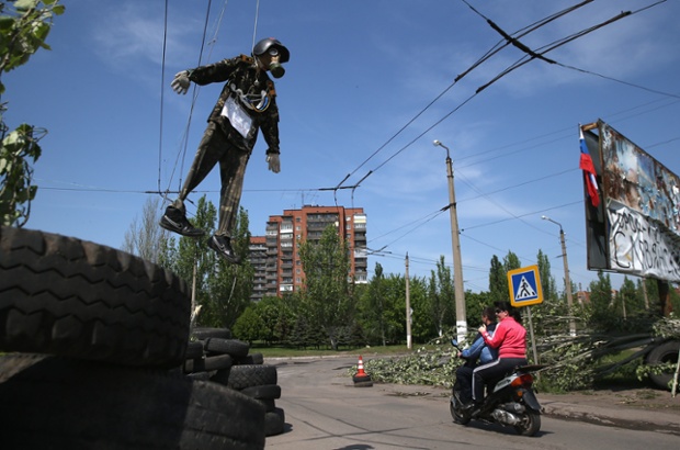 A couple on a scooter passes through a pro-Russian militia checkpoint in Slovyansk, Ukraine.