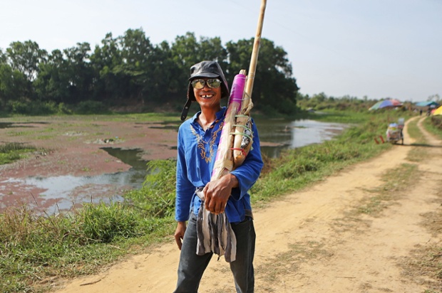 A man walks toward the launch site with his handmade rocket during the Bun Bang Fai rocket festival  in Yasothon, Thailand.