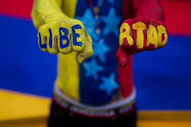 A demonstrator holds up his fists during a protest against Venezuela's president in Caracas.