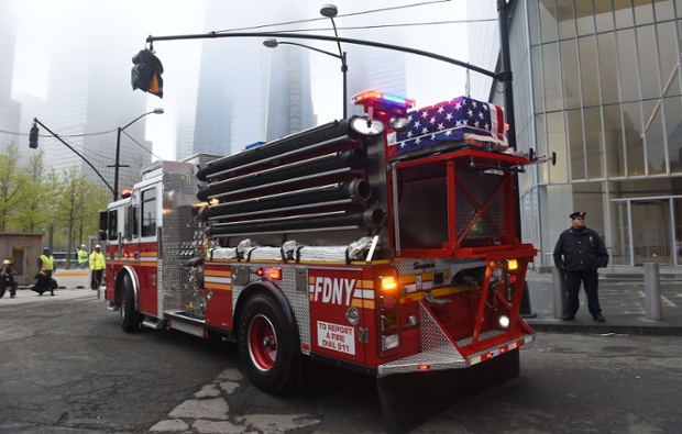 A casket carrying the unidentified remains of victims of the 11 September  attacks sits on top of a fire engine as the remains are escorted to a repository at Ground Zero in New York.