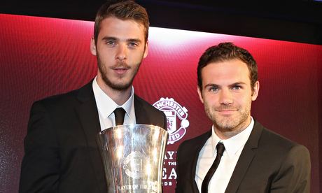 Manchester United's David de Gea is presented with an award by Juan Mata.