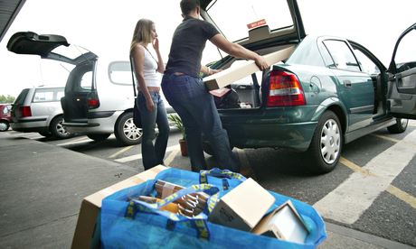 a couple loading IKEA furniture into car