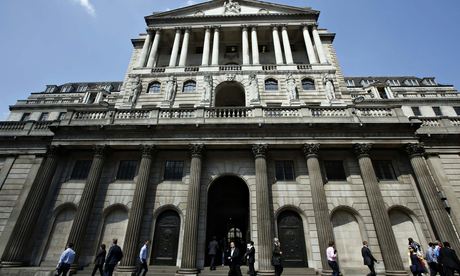 Pedestrians walk past the Bank of England in the City of London