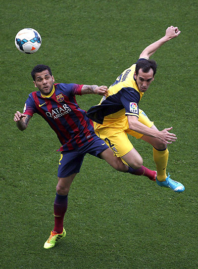 la liga: Daniel Alves goes up for a header with Diego Godin